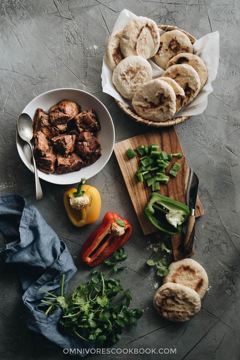 Flatbreads, braised pork belly, and chopped pepper and cilantro for making pork belly buns