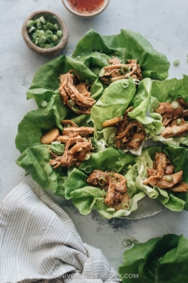 Instant pot shredded chicken lettuce wrap with Sriracha sauce and green onion on the side