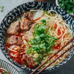 Lanzhou beef noodle soup features springy noodles, melt-in-your-mouth beef, a bit of homemade fresh chili oil, and a rich broth. It’s a simple dish but you can’t help but wonder about the magical power of a plain bowl of beef noodles.